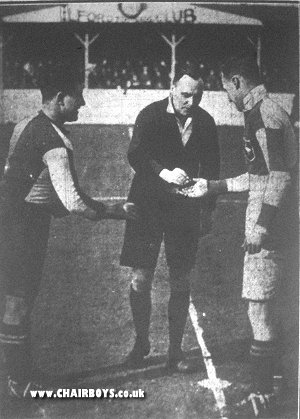 Referee J Lucas organises the spinning of the coin between Woking Captain Craddock (left) and Wanderers Captain Badrick prior to the game at Newbury Park - photo as published in the Bucks Free Press