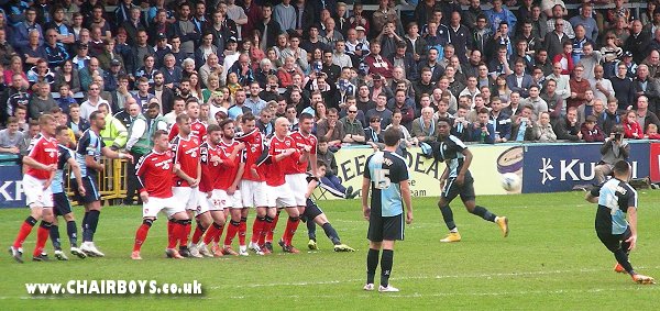 Nico Yennaris sees his free-kick blocked by a nine man wall against Morecambe
